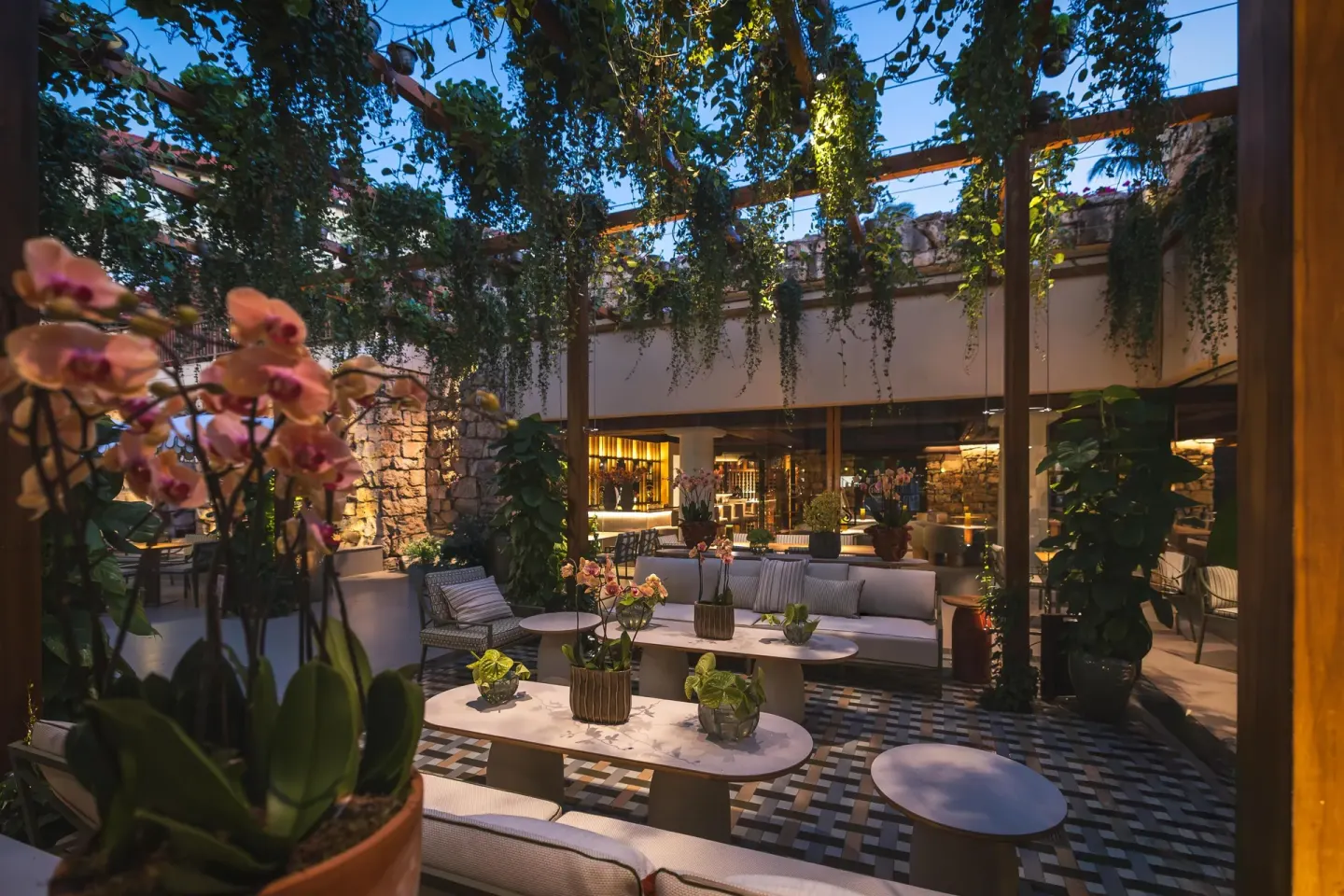Open-air lounge with orchids, sofas and hanging greenery at Hyatt Regency Aruba Resort and Casino.