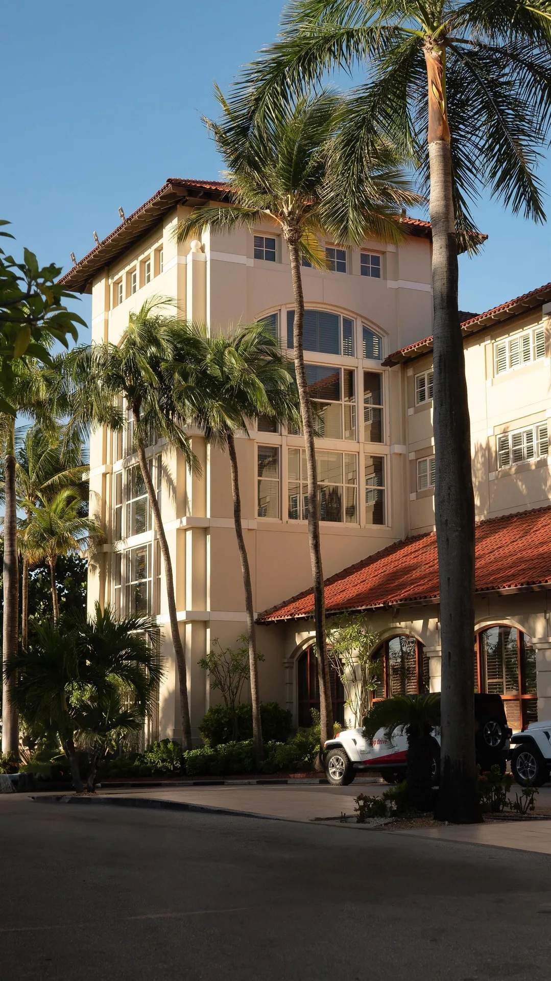 Palm-lined resort exterior with red tile roofs at Hyatt Regency Aruba Resort and Casino.