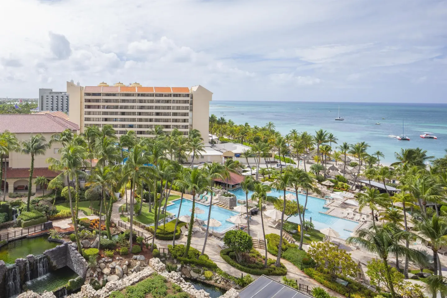 Aerial view of pools, gardens, and beachfront at Hyatt Regency Aruba Resort and Casino.