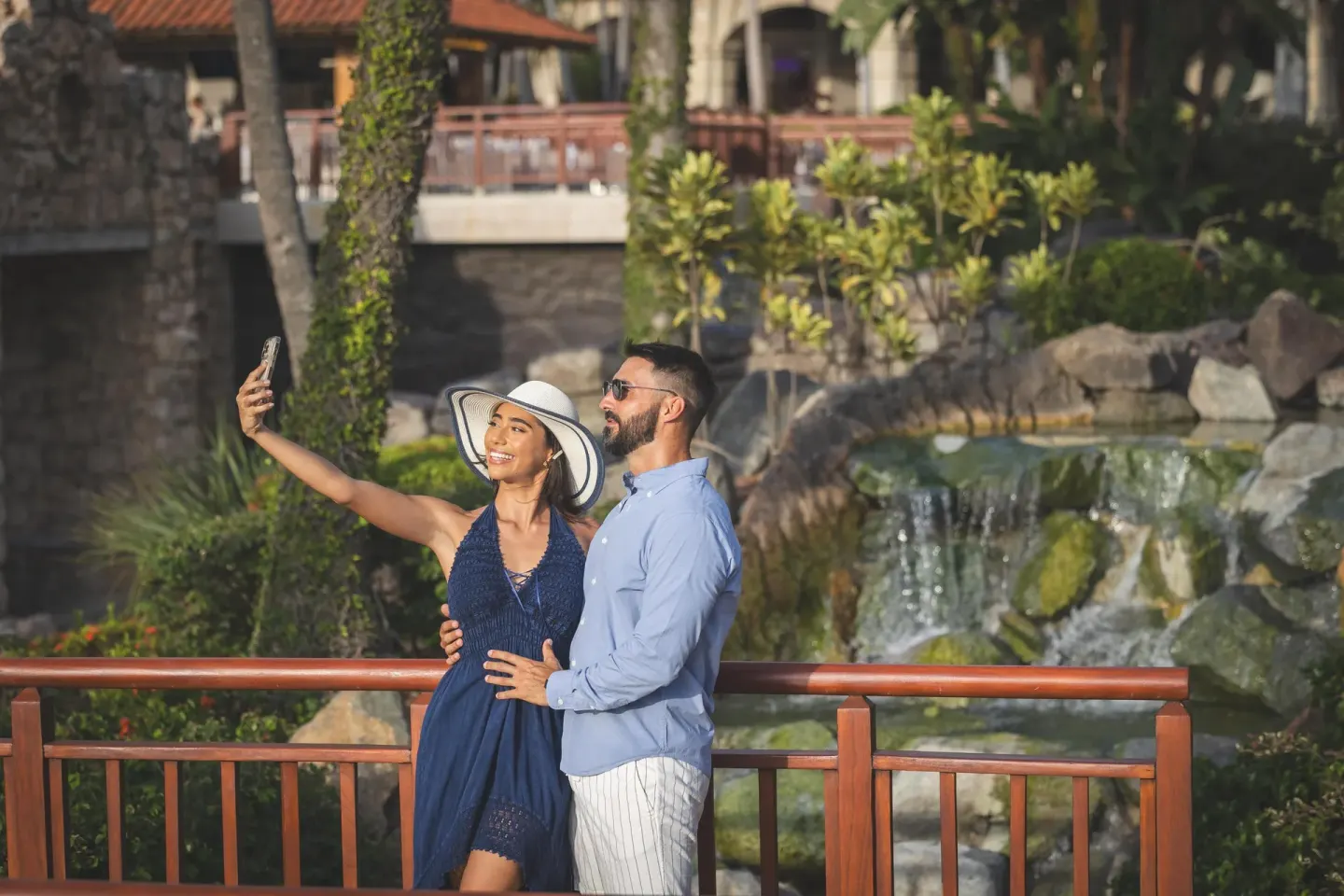 Couple taking a selfie by a waterfall at Hyatt Regency Aruba Resort and Casino.