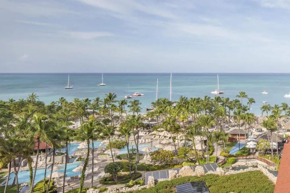 Family Suite resort view with pools, palms, and sailboats at Hyatt Regency Aruba Resort and Casino.