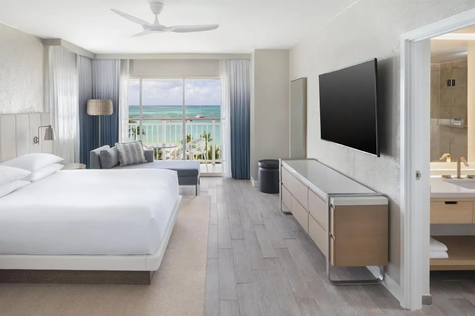 King bed room with ocean-facing balcony at Hyatt Regency Aruba Resort and Casino.