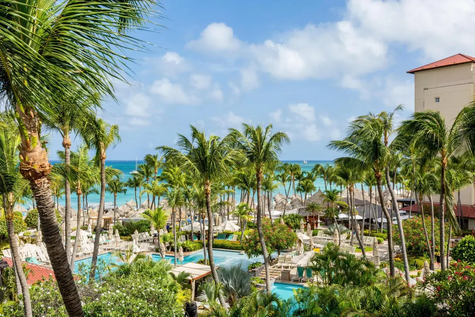 Resort view of pools, palms, beach, and ocean at Hyatt Regency Aruba Resort and Casino.