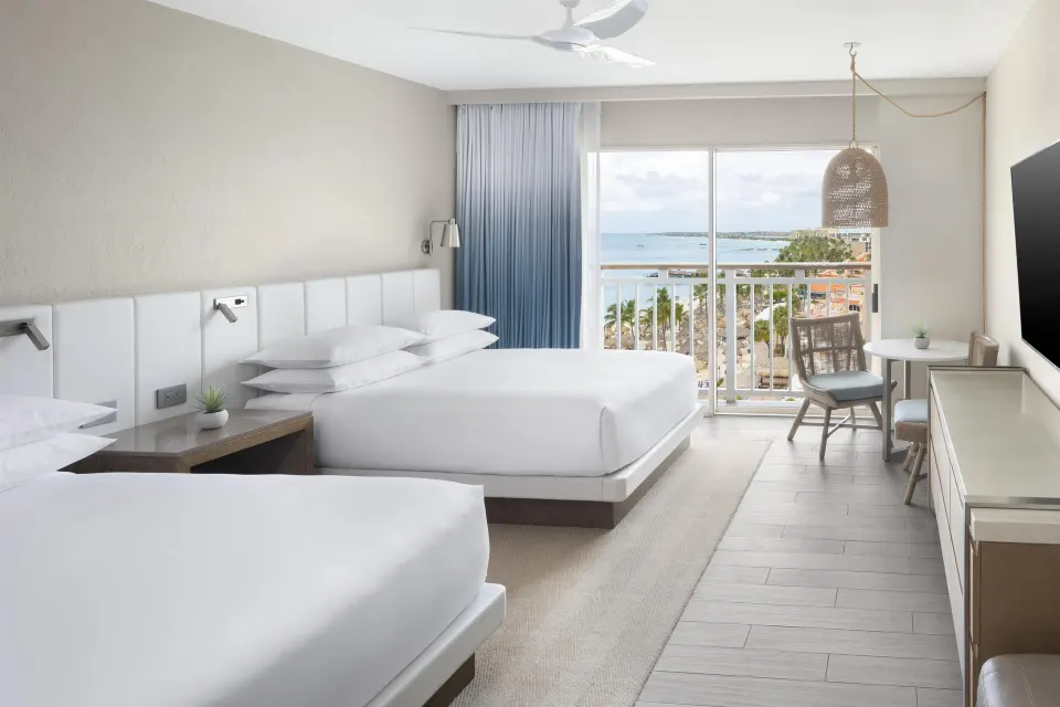 Two-bed guest room with ocean-facing balcony at Hyatt Regency Aruba Resort and Casino.