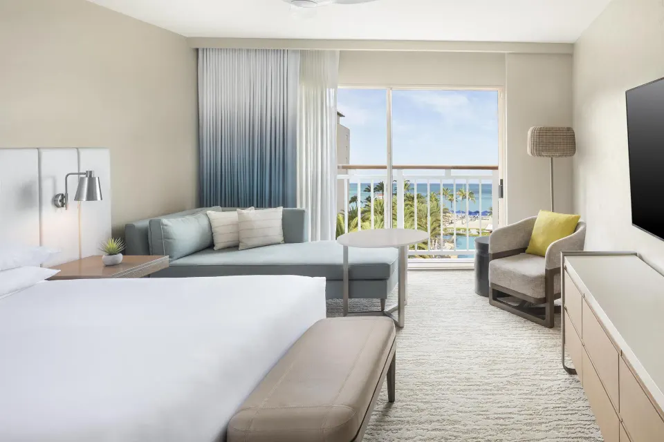 King room seating area with ocean and palm view at Hyatt Regency Aruba Resort and Casino.