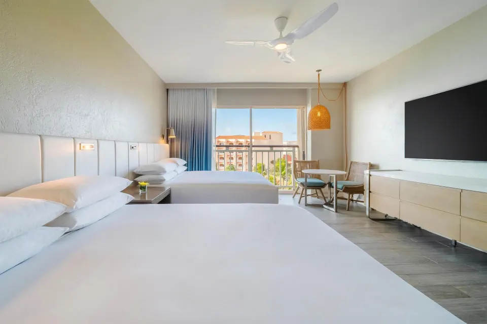 Two-bed resort view room with table and TV at Hyatt Regency Aruba Resort and Casino.