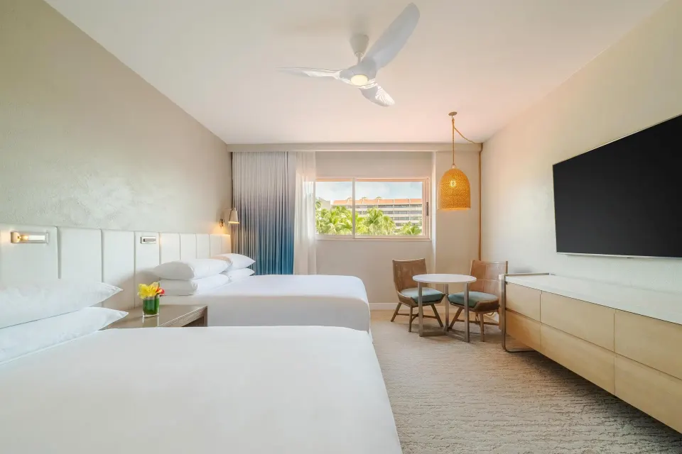 Guest room with two queen beds, wall TV and seating at Hyatt Regency Aruba Resort and Casino.