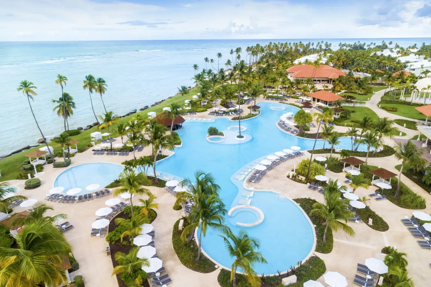 Aerial view of oceanfront pools and palm-lined grounds at Hyatt Regency Grand Reserve Puerto Rico.