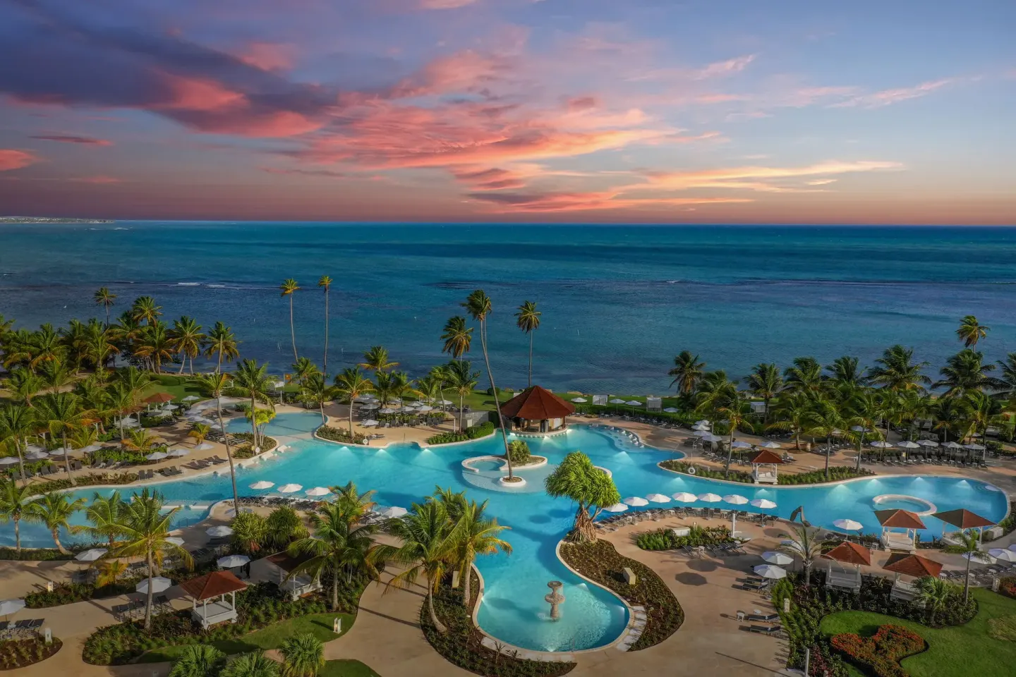 Aerial sunset view of pools, palms and ocean at Hyatt Regency Grand Reserve Puerto Rico.
