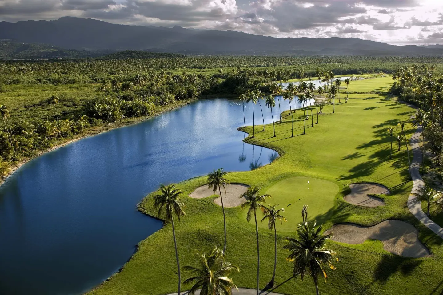Aerial golf course view with lake, palms, and mountains at Hyatt Regency Grand Reserve Puerto Rico.