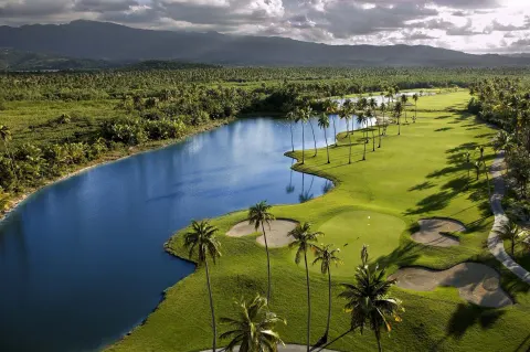 Aerial golf course view with lake, palms, and mountains at Hyatt Regency Grand Reserve Puerto Rico.