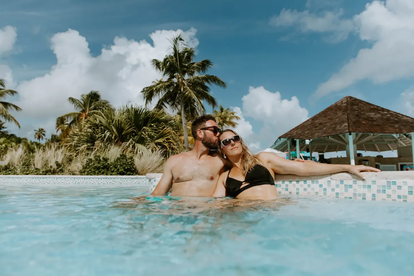 Guests relax in a palm-lined pool at Hyatt Regency Grand Reserve Puerto Rico.