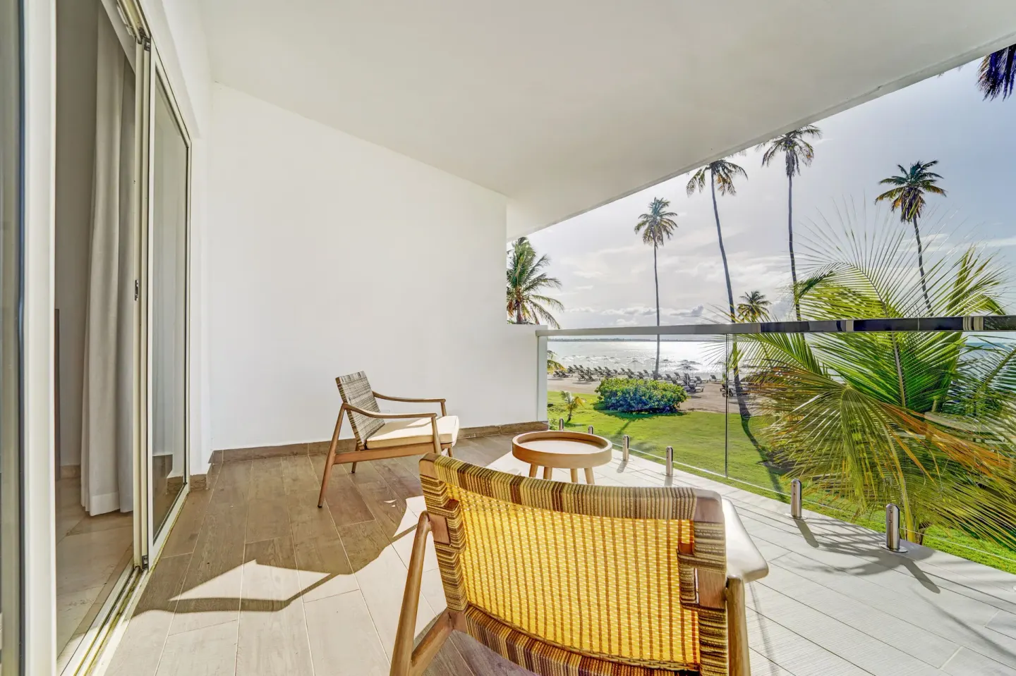 Oceanfront balcony with chairs and palm-framed water view at Hyatt Regency Grand Reserve Puerto Rico.