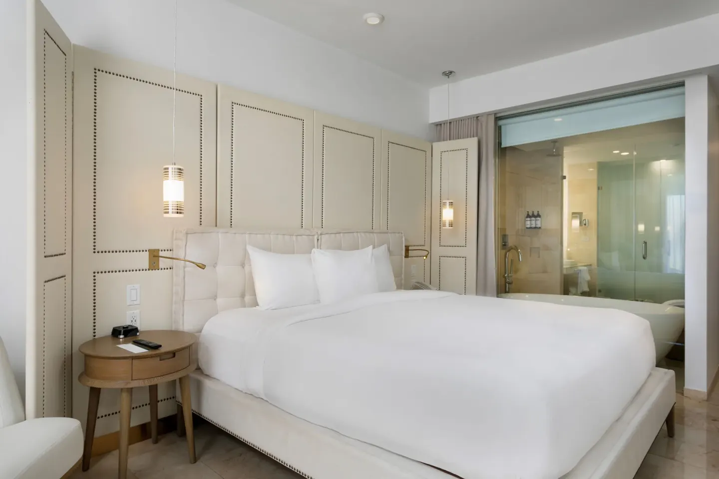 Oceanfront deluxe room king bed beside glass-walled bath at Hyatt Regency Grand Reserve Puerto Rico.