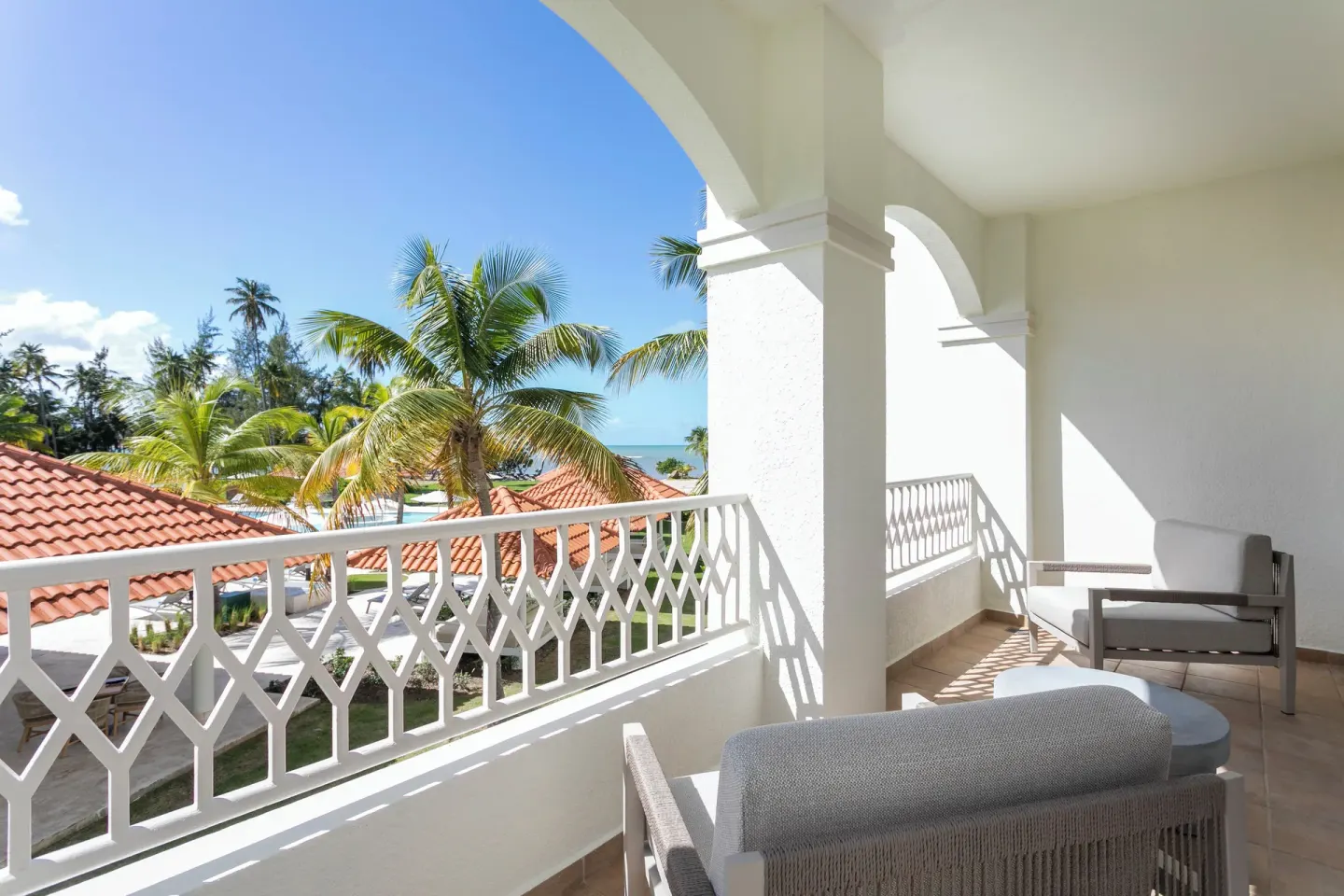 Deluxe Villa ocean-view balcony with chairs at Hyatt Regency Grand Reserve Puerto Rico.