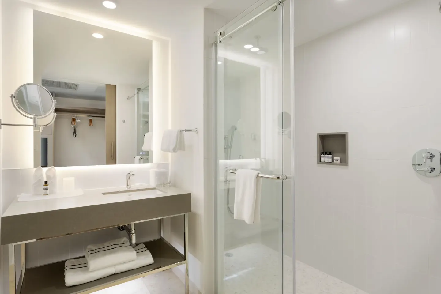 Guest room bathroom with illuminated vanity and glass shower at Hyatt Regency Grand Reserve Puerto Rico.