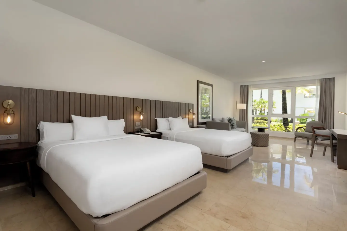 Two-queen guest room with lounge seating at Hyatt Regency Grand Reserve Puerto Rico.
