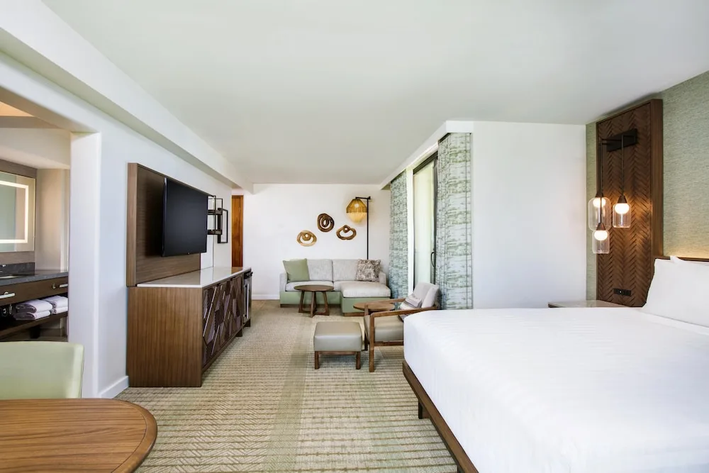 King guest room with seating area, TV console, and vanity at Hyatt Regency Maui Resort & Spa.