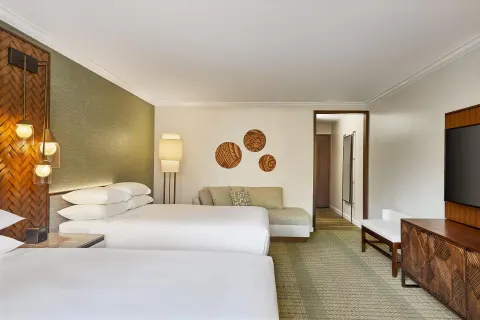 Two-bed guest room with sofa and wall-mounted TV at Hyatt Regency Maui Resort & Spa.