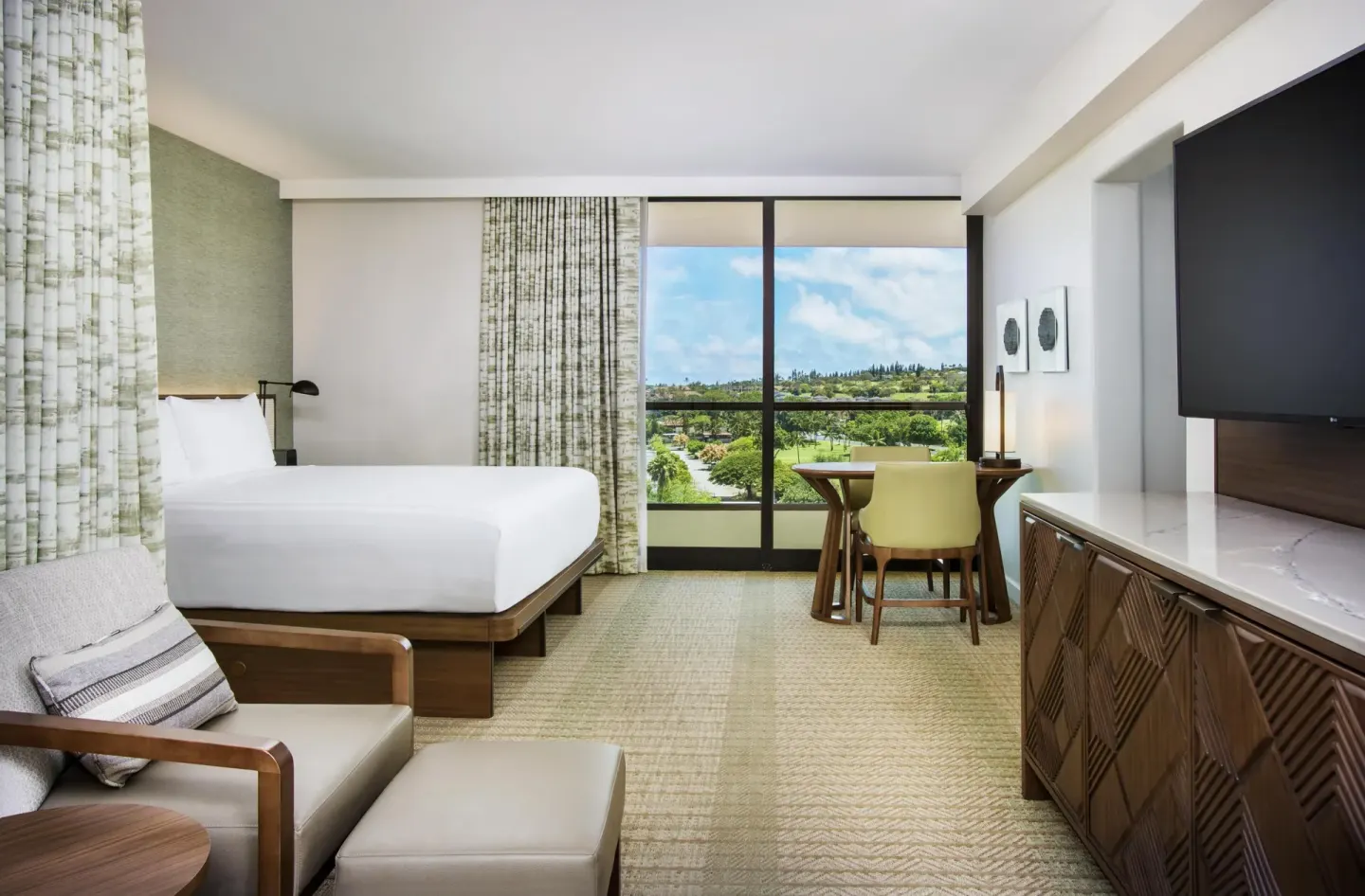 King guest room with desk, TV console, and green view at Hyatt Regency Maui Resort & Spa.
