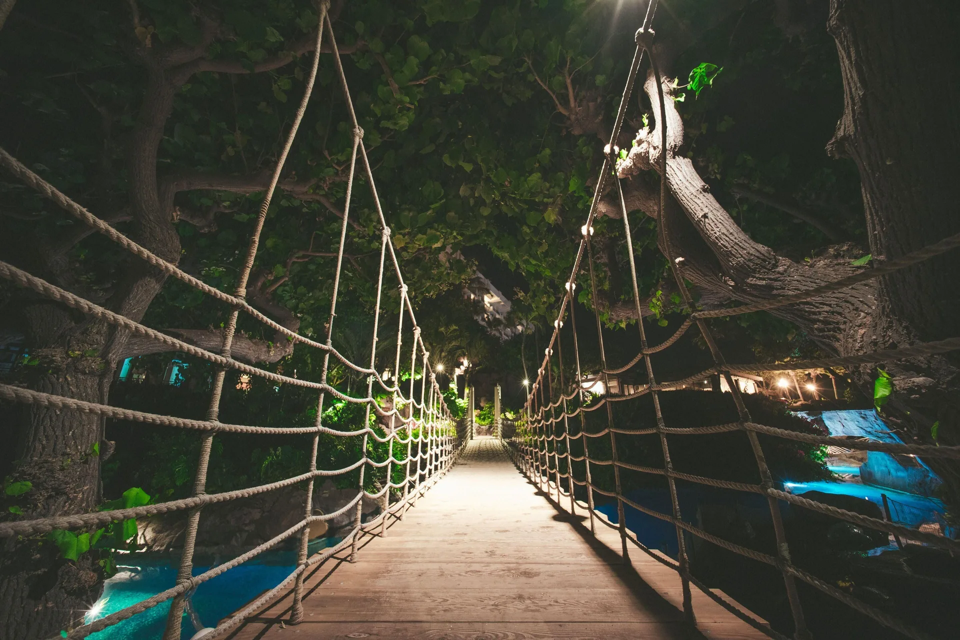 Rope bridge over water at night at Hyatt Regency Maui Resort & Spa.