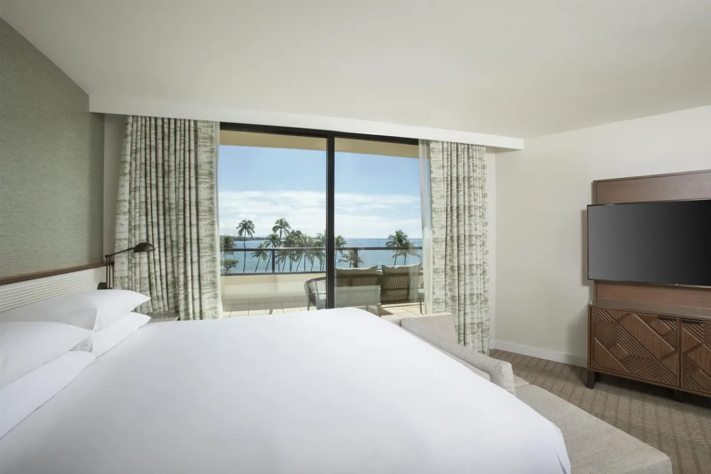 King bed guest room with ocean-view balcony at Hyatt Regency Maui Resort & Spa.
