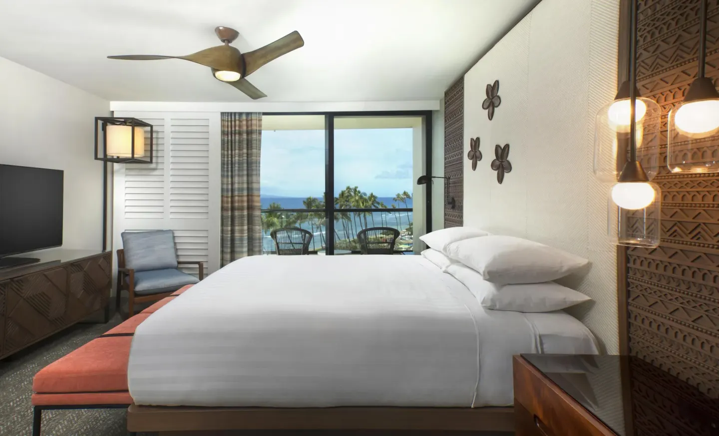 King guest room with ocean-view balcony and carved wood accents at Hyatt Regency Maui Resort & Spa.