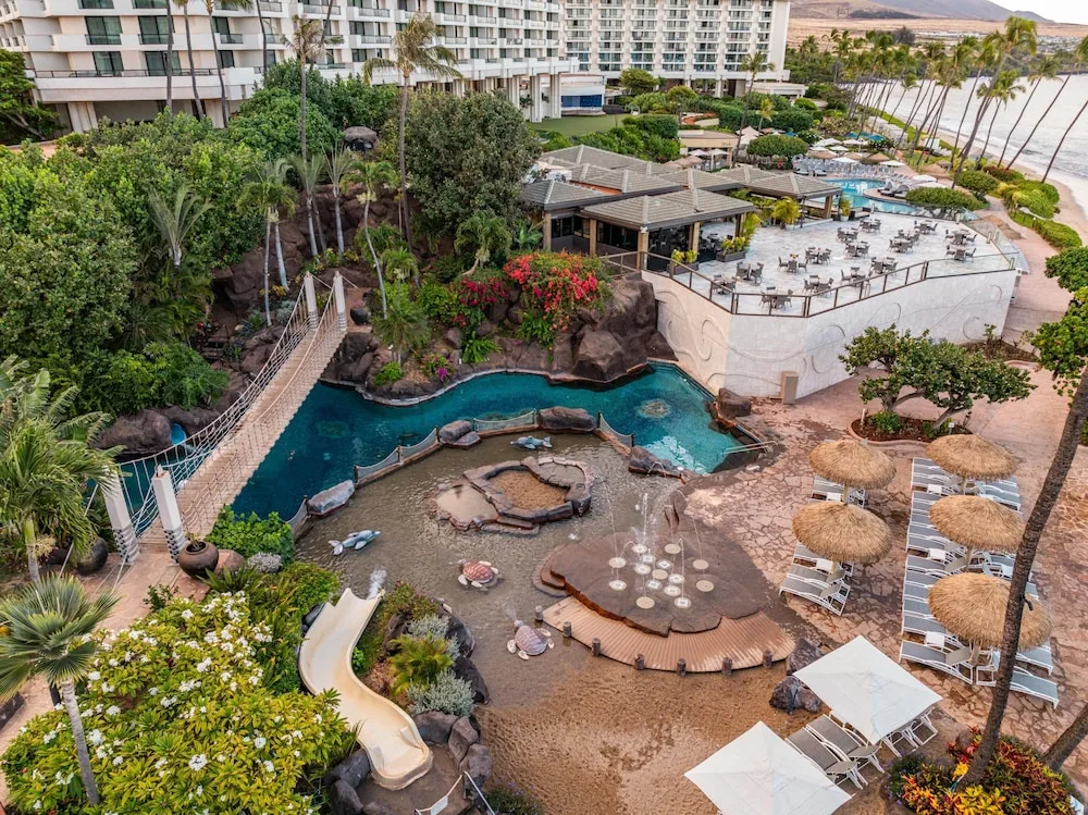Pool area with slide, bridge, and lounge chairs at Hyatt Regency Maui Resort & Spa.