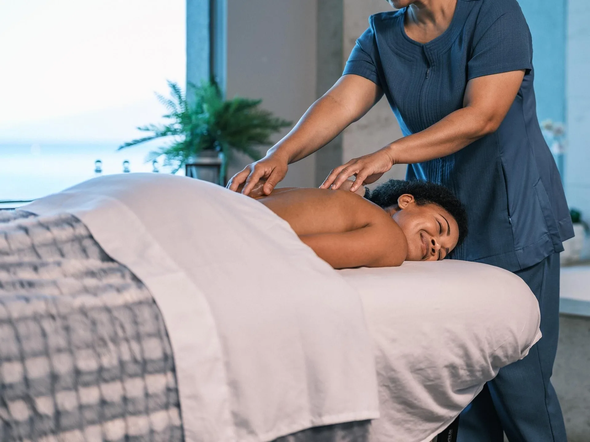 Spa therapist giving a massage in a treatment room at Hyatt Regency Maui Resort & Spa.