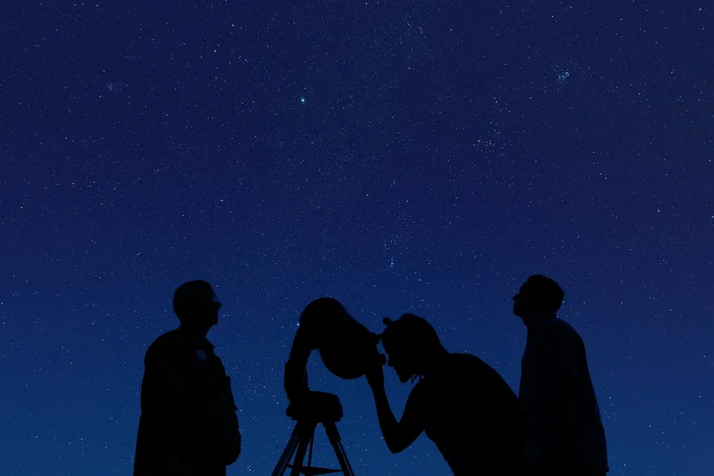 Guests stargaze through a telescope at Hyatt Regency Maui Resort & Spa.