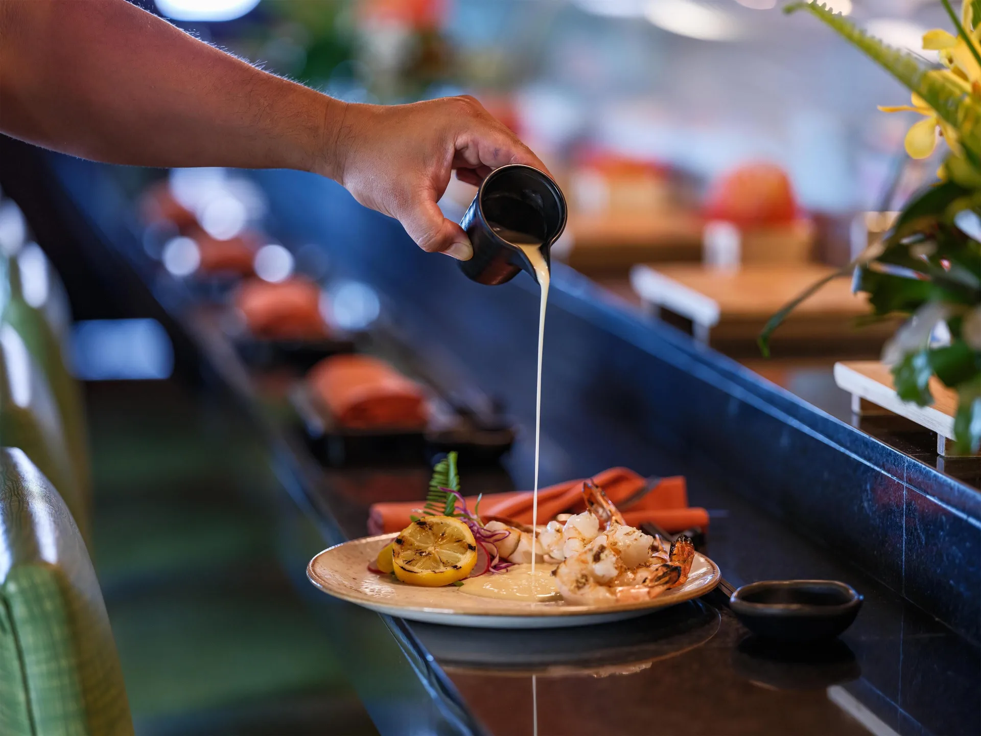 Sauce being poured over grilled seafood at Hyatt Regency Maui Resort & Spa.