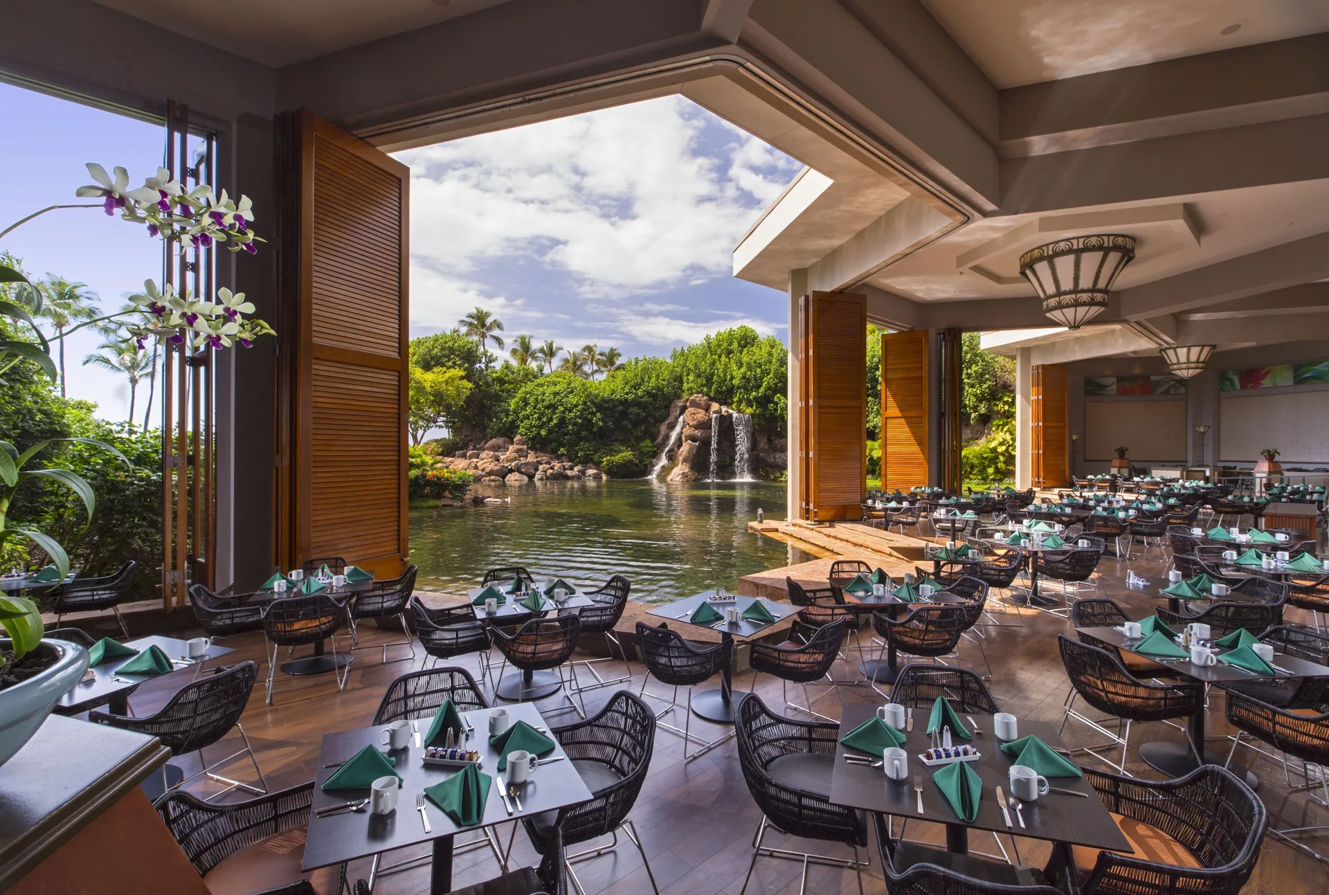 Open-air dining room beside a lagoon waterfall at Hyatt Regency Maui Resort & Spa.