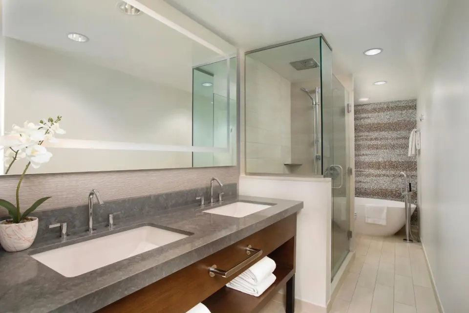 Deluxe Suite ocean bathroom with double vanity and glass shower at Hyatt Regency Maui Resort & Spa.