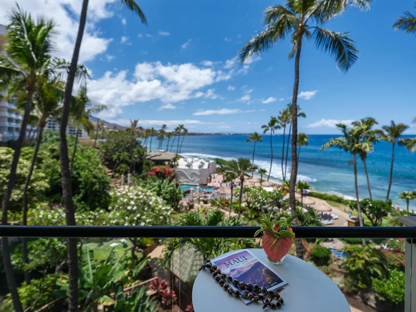 Balcony ocean view with table, palms and resort grounds at Hyatt Regency Maui Resort & Spa.