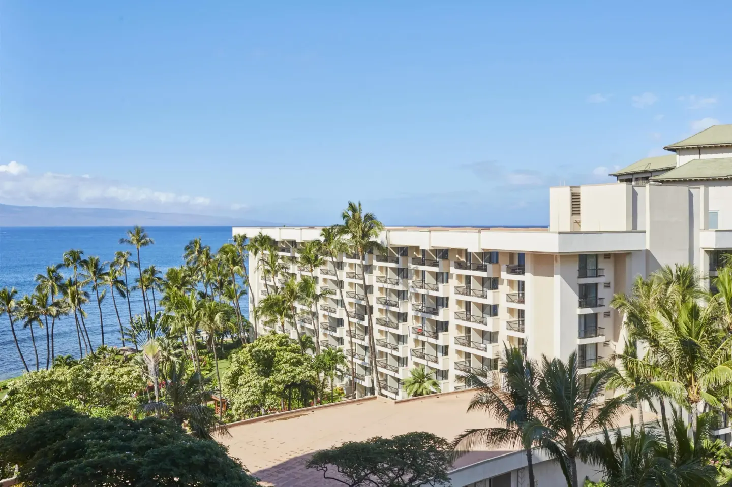 Partial ocean view over palms and resort balconies at Hyatt Regency Maui Resort & Spa.
