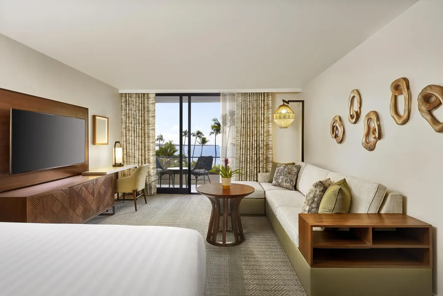 Ocean view guest room with bed, sofa bed, TV, balcony, and palm trees at Hyatt Regency Maui Resort & Spa.
