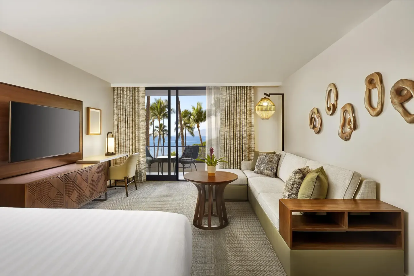 Oceanfront room with sofa bed, king bed and palm-framed balcony at Hyatt Regency Maui Resort & Spa.