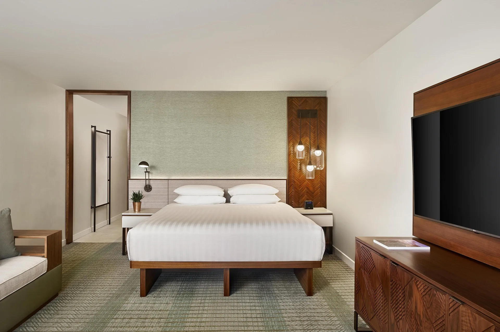 Room with king bed, sofa bed, and wall-mounted TV at Hyatt Regency Maui Resort & Spa.