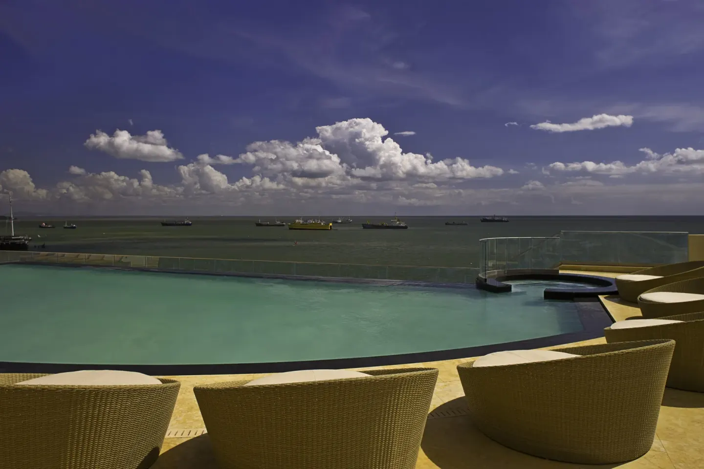 Infinity pool and curved lounge chairs facing the sea at Hyatt Regency Trinidad.