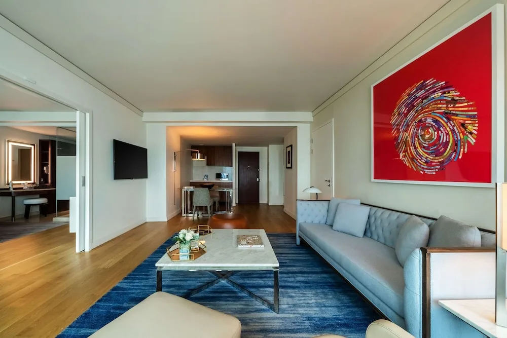 Suite living room with sofa, blue rug and red wall art at Hyatt Regency Trinidad.