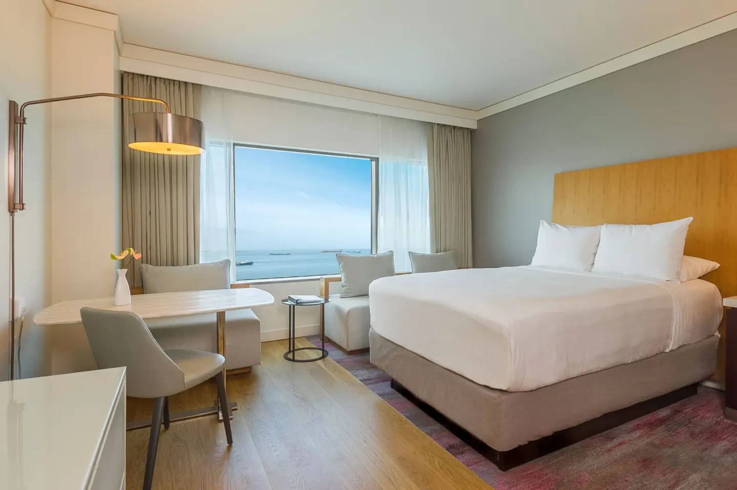 King bed guest room with harbor view and seating at Hyatt Regency Trinidad.