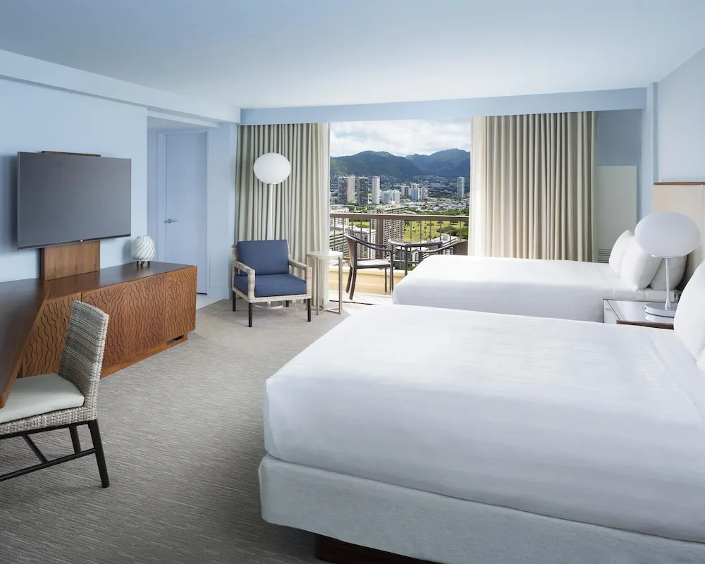 Two-bed guest room facing mountain-view balcony at Hyatt Regency Waikiki Beach Resort & Spa.