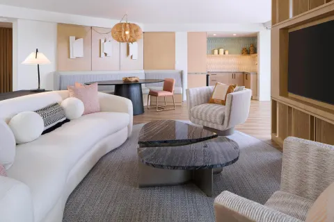 Deluxe suite lounge with sofa, chairs, TV, and wet bar at Hyatt Regency Waikiki Beach Resort & Spa.