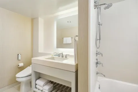 Bathroom vanity, toilet and shower-tub in a One Bedroom Ocean Front Suite at Hyatt Regency Waikiki Beach Resort & Spa.