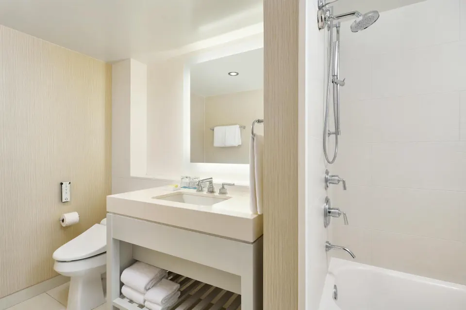 Bathroom vanity, toilet and shower-tub in a One Bedroom Ocean Front Suite at Hyatt Regency Waikiki Beach Resort & Spa.