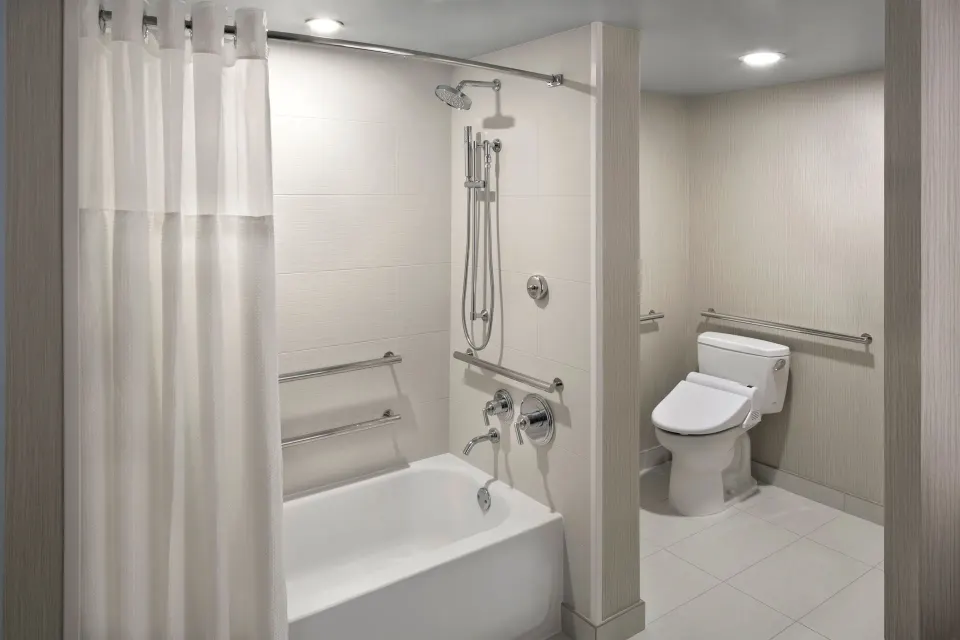 Accessible bathroom with bathtub and grab bars at Hyatt Regency Waikiki Beach Resort & Spa.