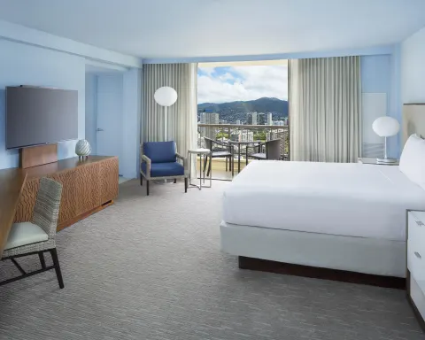 King bed guest room with city view balcony at Hyatt Regency Waikiki Beach Resort & Spa.