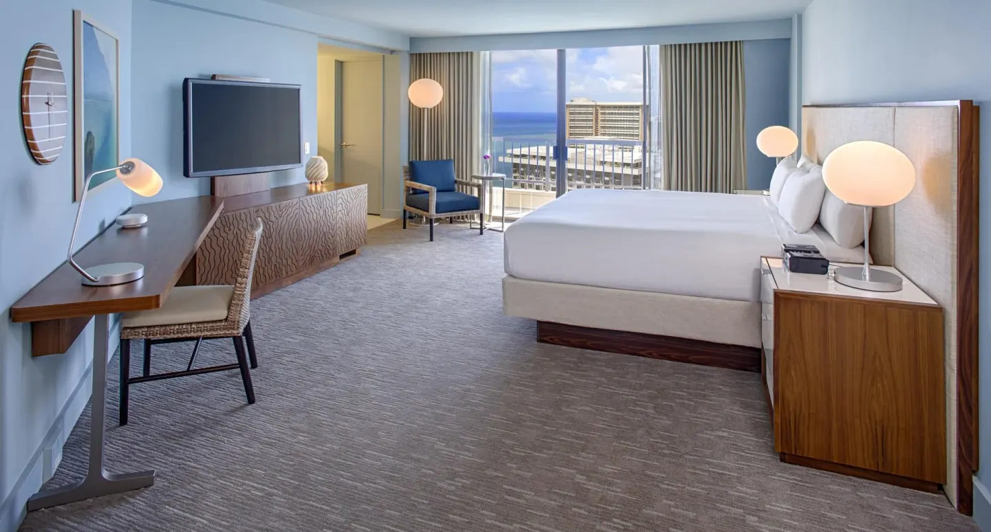 King bed Ocean View room at Hyatt Regency Waikiki Beach Resort & Spa with desk and balcony.