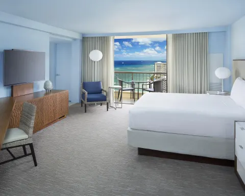 King bed Ocean View room at Hyatt Regency Waikiki Beach Resort & Spa with balcony beyond curtains.