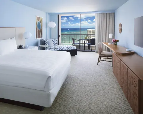 King bed Ocean View room at Hyatt Regency Waikiki Beach Resort & Spa with chaise and balcony.